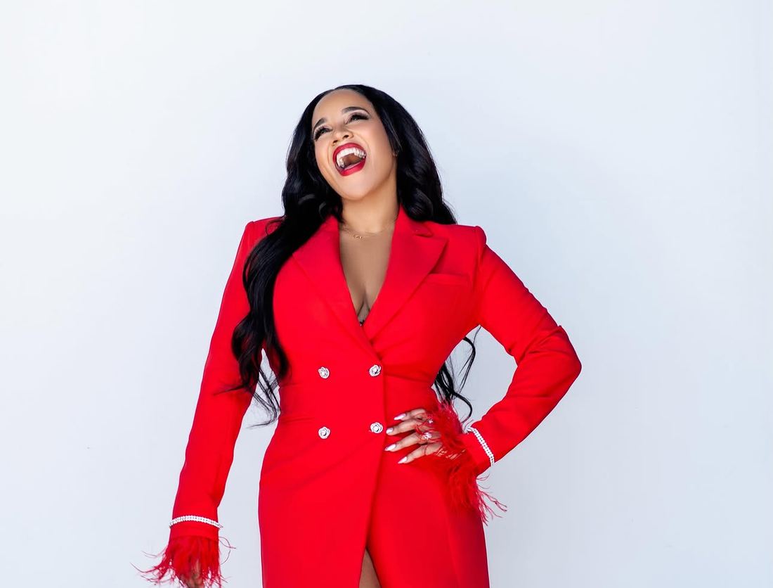 Lahteefah Parramore laughing, in a red suit